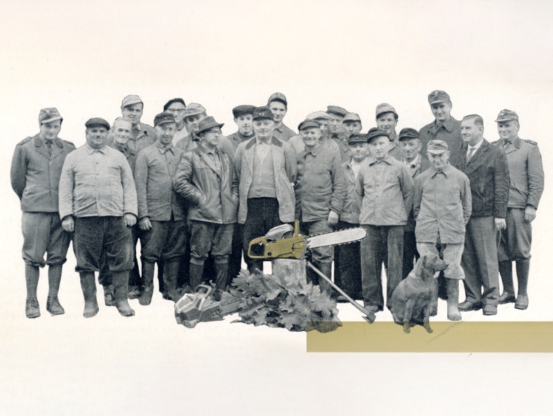Schwarz‑wei&szlig;-Fotografie einer Gruppe von Waldarbeitern mit einer S&auml;ge und einem Hund; einzelne Elemente sind goldfarben koloriert.