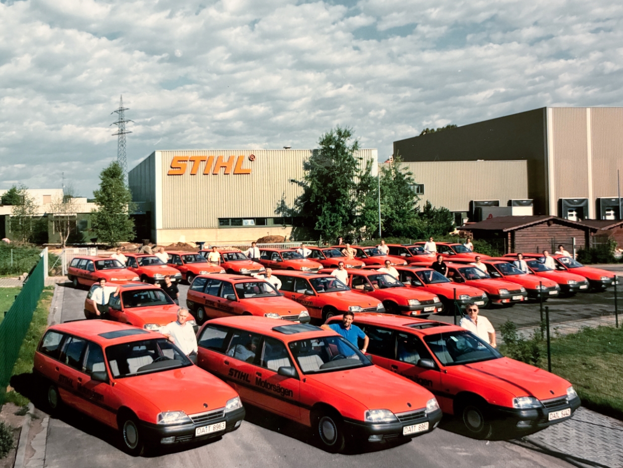 Ein Fuhrpark roter Autos vor einem STIHL Geb&auml;ude.