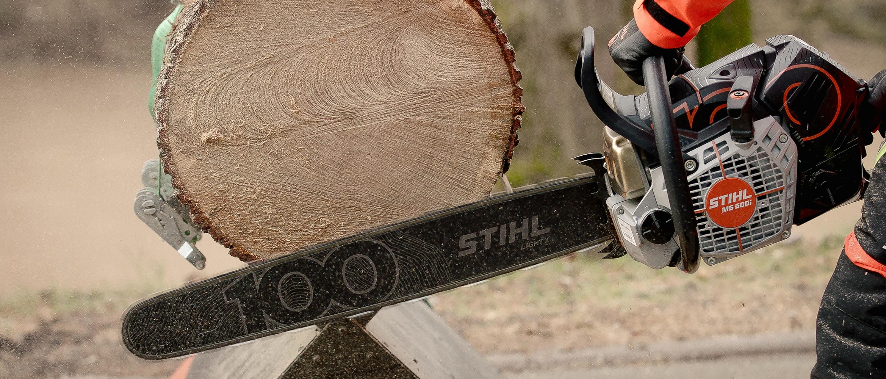 Die Jubil&auml;umsmotors&auml;ge von STIHL im Einsatz beim Zerteilen eines Baumstamms.