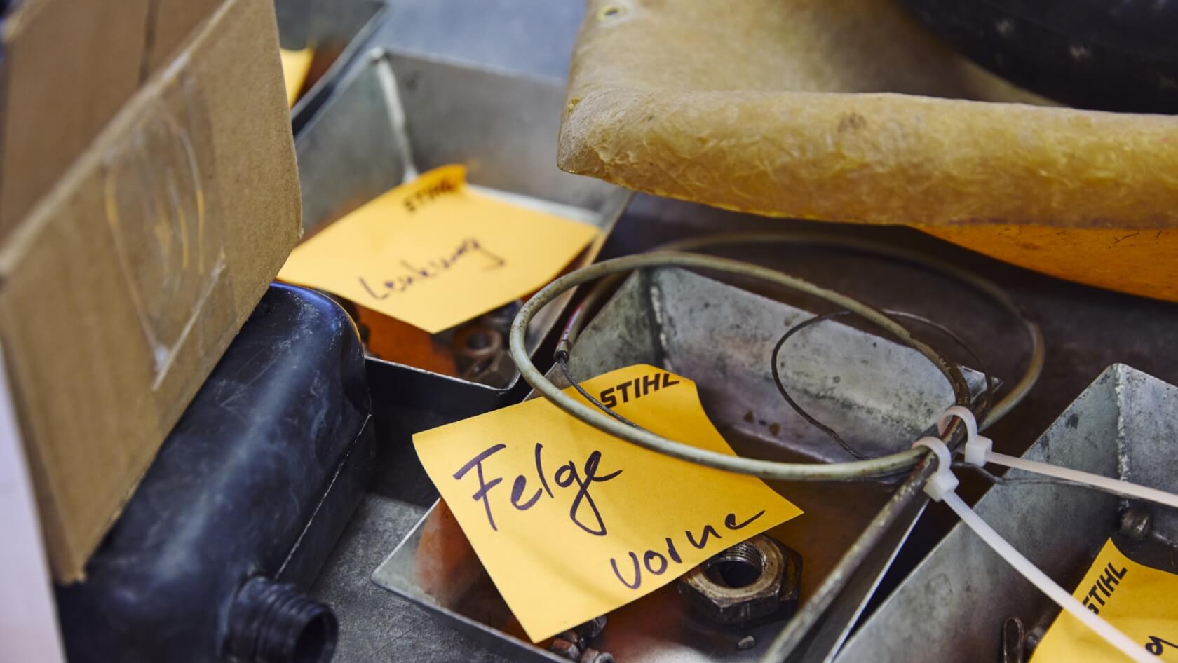 Detailaufnahme von Einzelteilen eines Gokarts mit der Beschriftung &bdquo;Felge vorne&ldquo;.