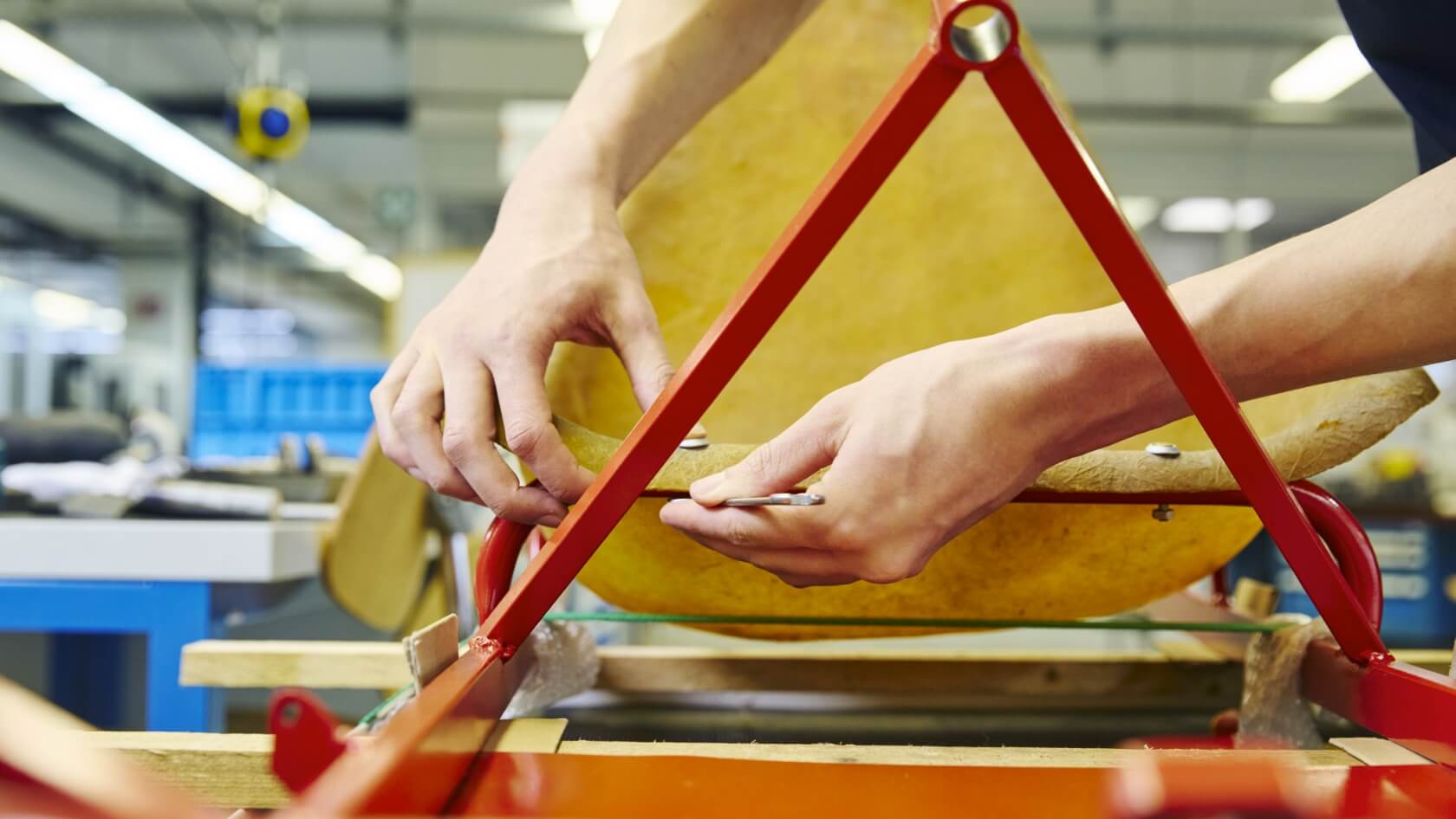 Nahaufnahme von zwei H&auml;nden, die eine Schraube an einem Gokart festziehen.